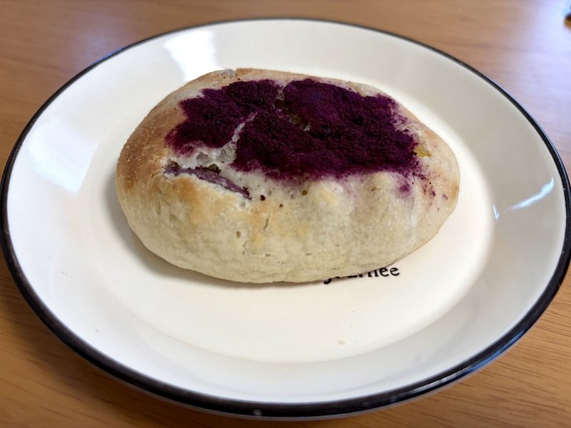 Baker thetaのさつまいものパン。丸いパンの上に紫芋のパウダーがかかっている