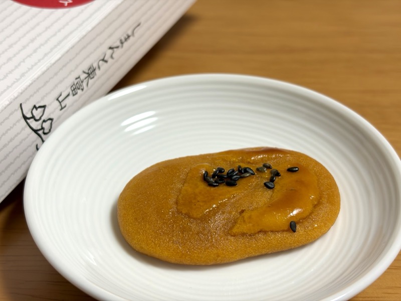 お皿にのせたひがしやま。鮮やかなオレンジ色で黒ごまがのっている