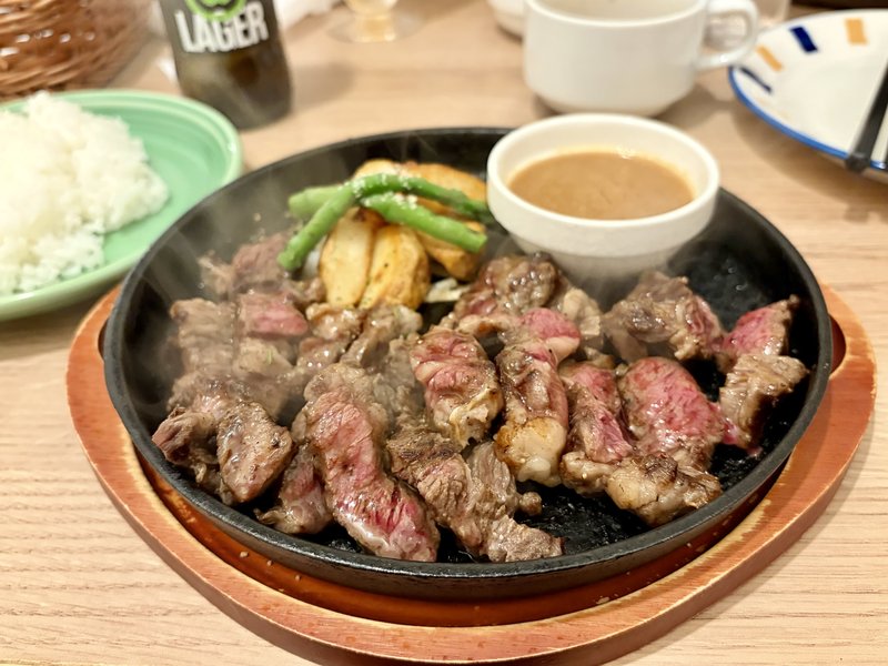 ペコラパスタのステーキランチ。熱々の鉄板にのった国産牛のステーキと、別添えの自家製ジャポネソース、付け合わせのポテトとインゲン