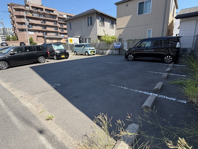 レールサイド珈琲の奥にある駐車場。区画が並び、車止めのある屋外駐車場