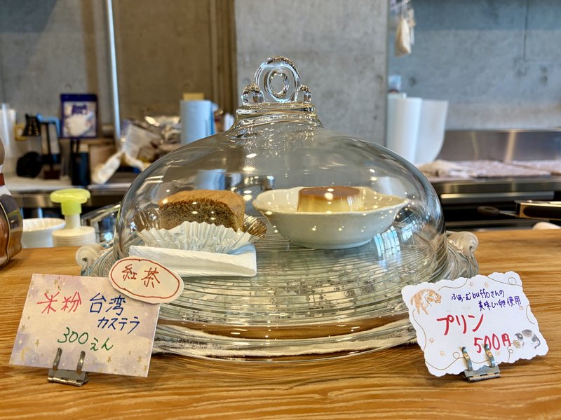 レールサイド珈琲のショーケース。「ふぁーむbuffoさんの美味しい卵使用 プリン 500円」の手書きの札が置かれている